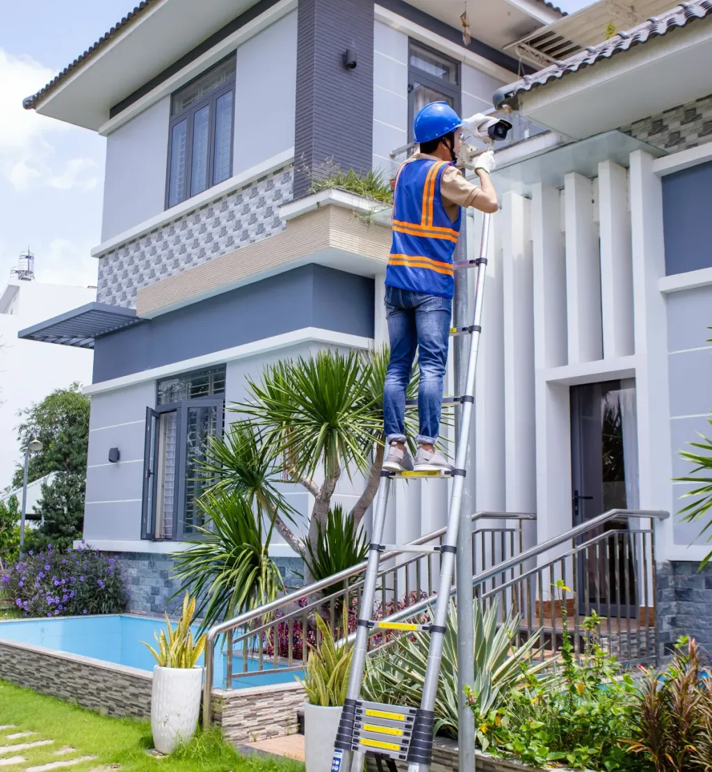 Inspector on a ladder checking a house